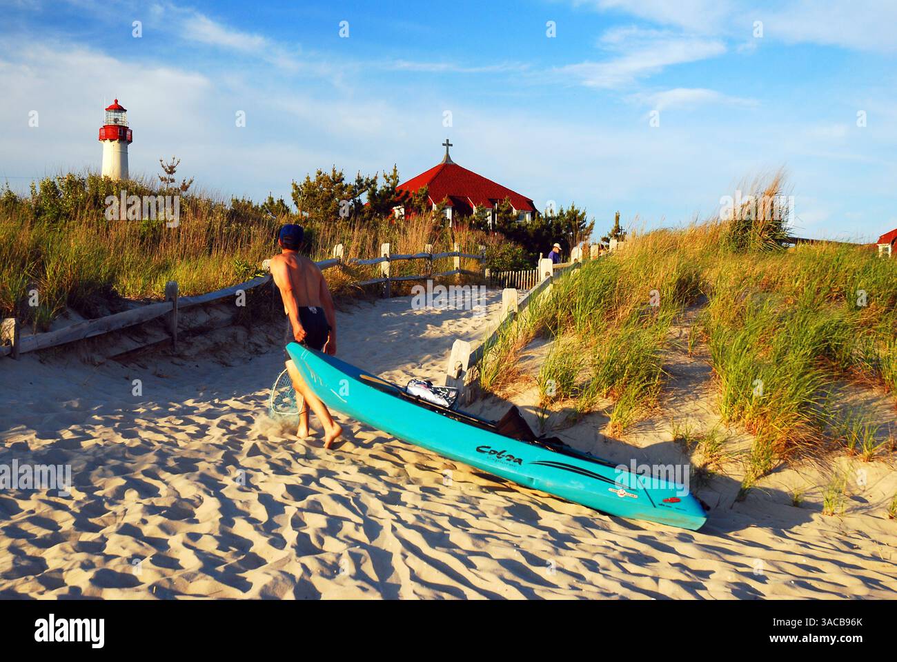 Un jeune homme traîne son kayak de la plage à la fin de la journée à Cape May New Jersey, sur la côte du Jersey Banque D'Images