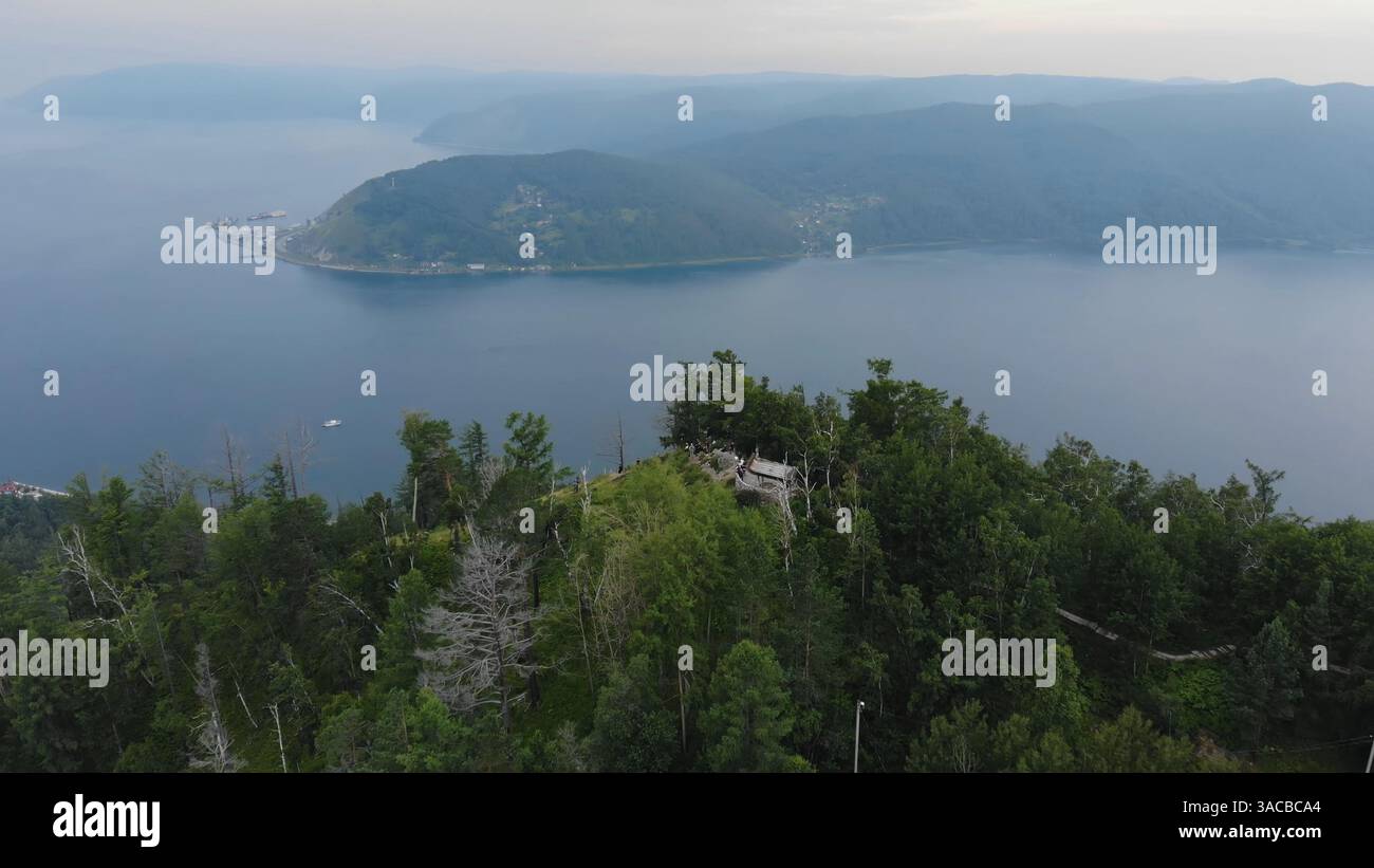 Lac Baïkal dans la soirée. Vue aérienne d'un pont d'observation en bois niché dans une forêt, surplombant la vaste étendue du lac baïkal et le lointain Banque D'Images