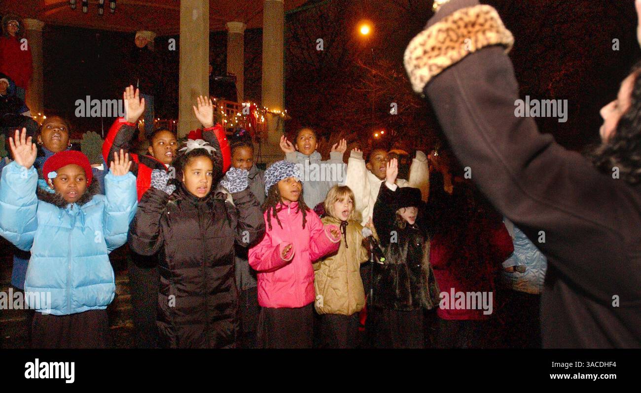 11 décembre 2004 - Cincinnati, Ohio, États-Unis - dirigé par Della Enns, (R), vingt enfants du quartier OTR, membres du programme parascolaire "Art and Soul on Vine", chantent des chansons de Noël alors qu'ils participent au programme Luminaria Harmony of Light à Washington Park, fondé par Thomas Courtney en 2000 à la suite des émeutes de Cincinnati, pour les résidents d'Over-the Rhin. (Crédit image : © Ken Stewart/ZUMA Press) Banque D'Images