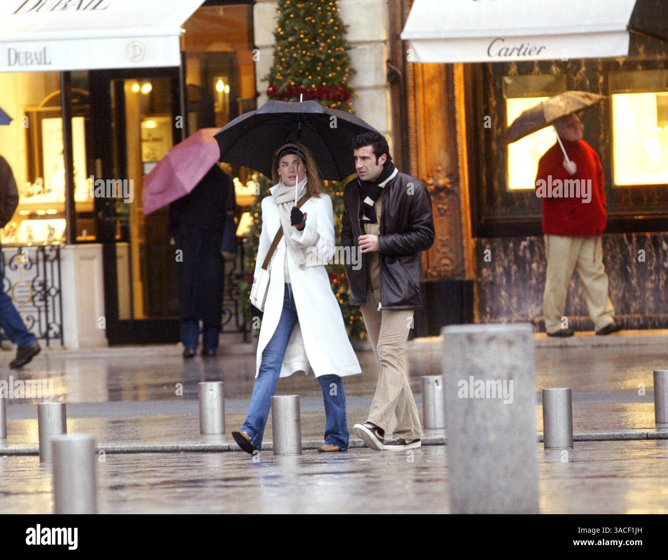 27 décembre 2002 ; Paris, France ; le footballeur du Real Madrid LUIS FIGO et sa femme HELEN SVEDIN prennent de courtes vacances loin des enfants pour faire du shopping et profiter de la compagnie de l'autre sous la pluie humide de Paris. Ils ont rendu visite à trois ou quatre bijoutiers où Luis a acheté des cadeaux pour sa belle épouse. Banque D'Images