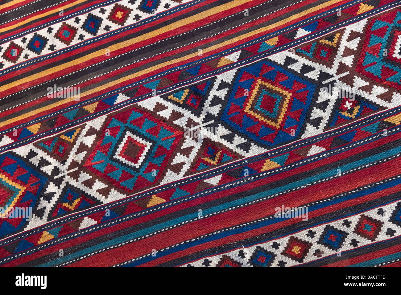 Tapis coloré en laine azerbaïdjanaise avec détails géométriques complexes et contrastes de couleurs audacieux de motifs ethniques. Gros plan avec mise au point sélective Banque D'Images