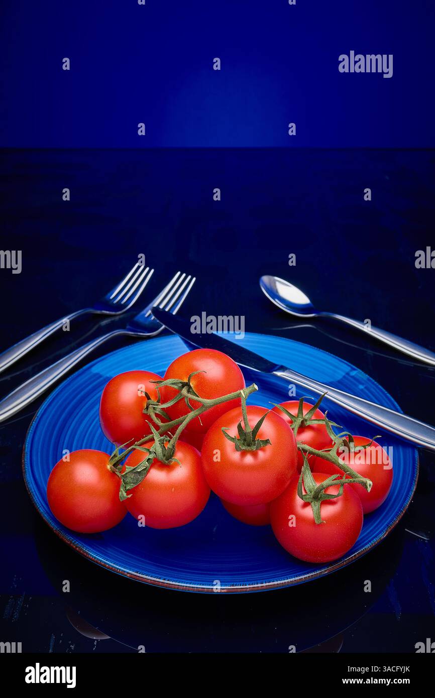 Tomates, vigne mûrie sur assiette Banque D'Images