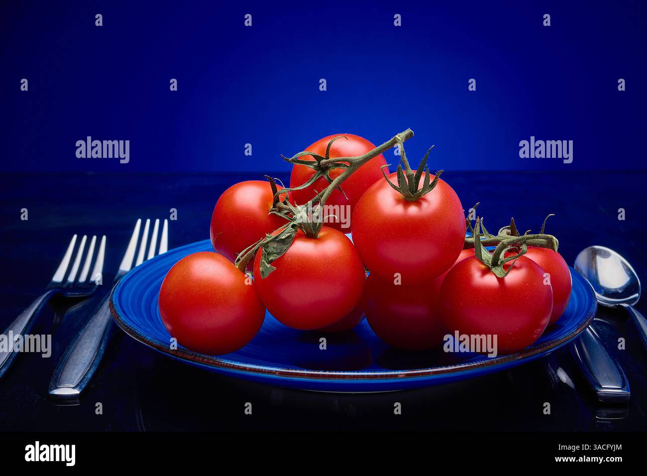 Tomates, vigne mûrie sur assiette Banque D'Images