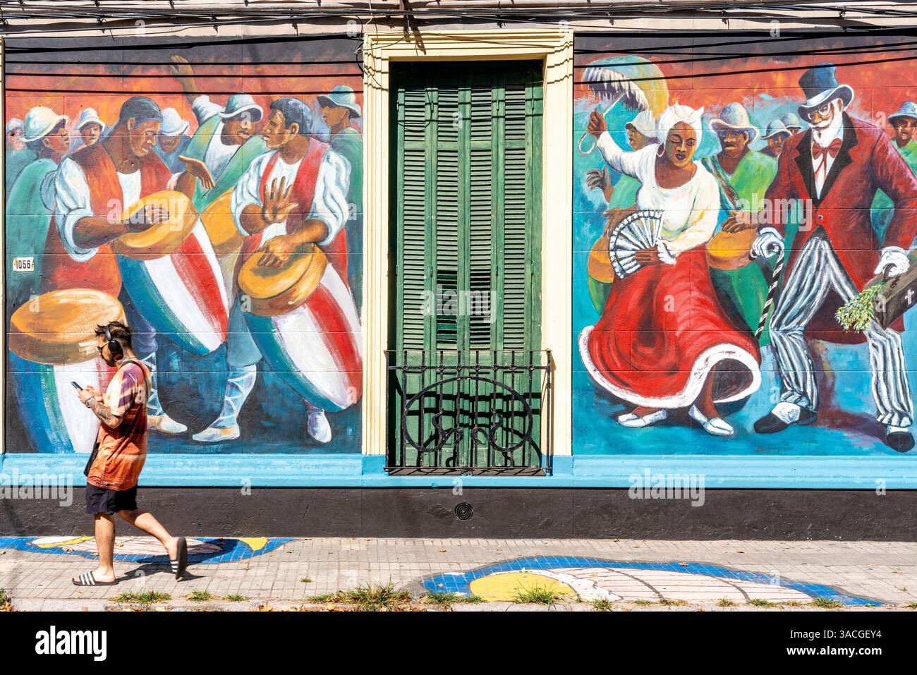 Un homme du coin passe devant Une maison colorée peinte dans le quartier de Barrio sur à Montevideo, Uruguay. Banque D'Images