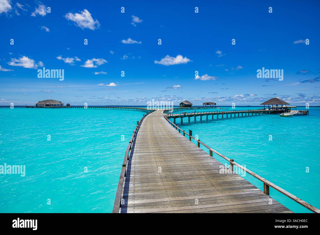 Destination de voyage de luxe, merveilleux lagon de l'océan relaxant. Jetée de promenade en bois et villas sur l'eau dans l'horizon tropical de la mer de l'hôtel. Vacances d'été Banque D'Images