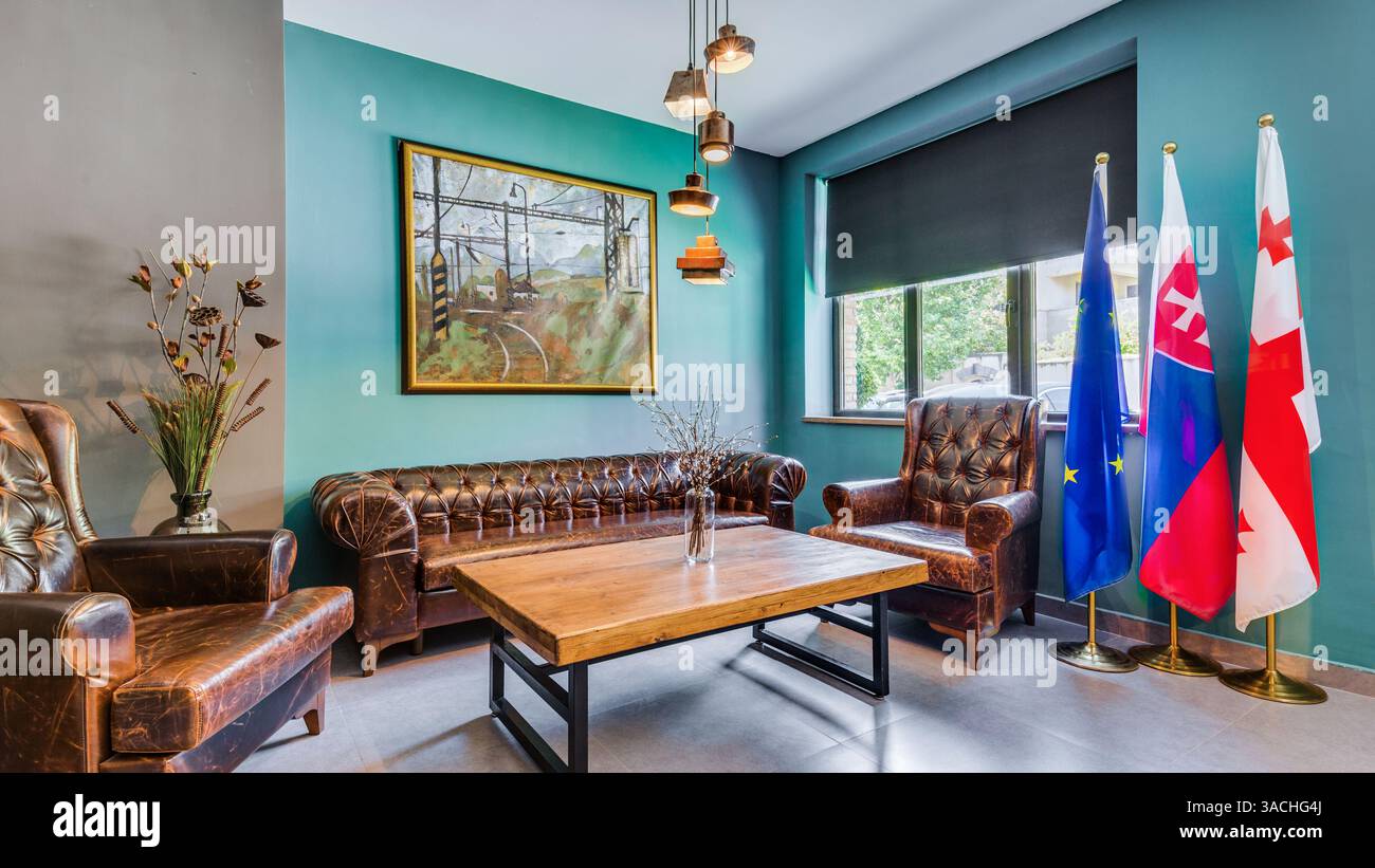 Un intérieur Cozy Corner avec des meubles en cuir, de l'art et des drapeaux de campagne pour une ambiance unique dans un espace élégant et moderne Banque D'Images