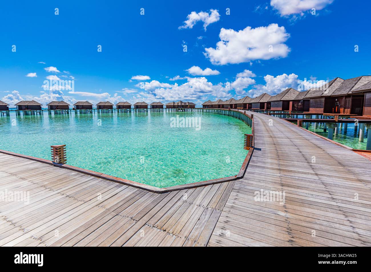Belles villas sur l'eau aux Maldives avec pont de pied de jetée en bois au soleil, concept de voyage de vacances. Destination de luxe, mer tropicale immaculée Banque D'Images