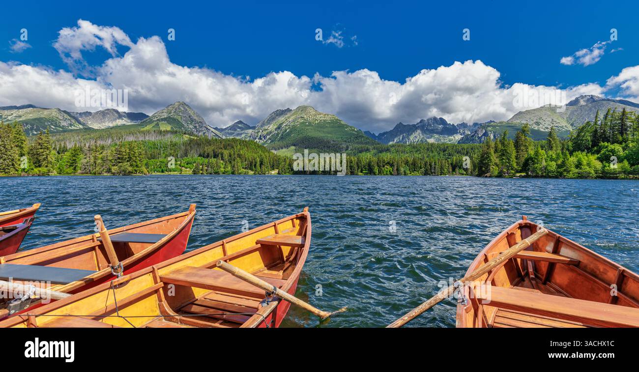 Bateaux pittoresques sur le lac Tatra entouré de montagnes majestueuses en Slovaquie. Paysage tranquille avec des eaux bleues claires et des arrière-plans alpins Banque D'Images