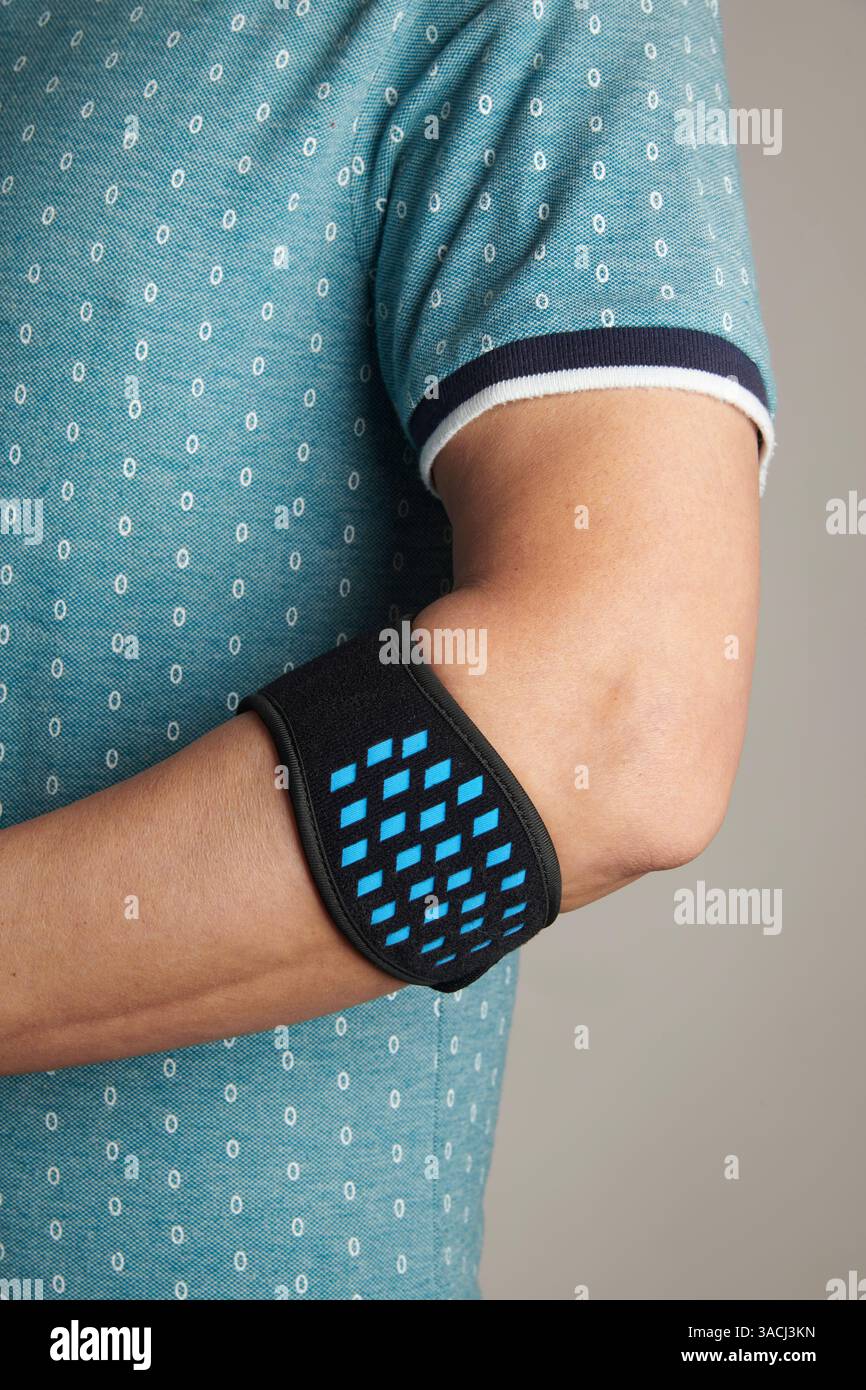 gros plan d'un homme portant un bracelet d'épicondylite sur son bras, pour soulager la douleur de l'épicondylite, également connu sous le nom de tennis elbow Banque D'Images