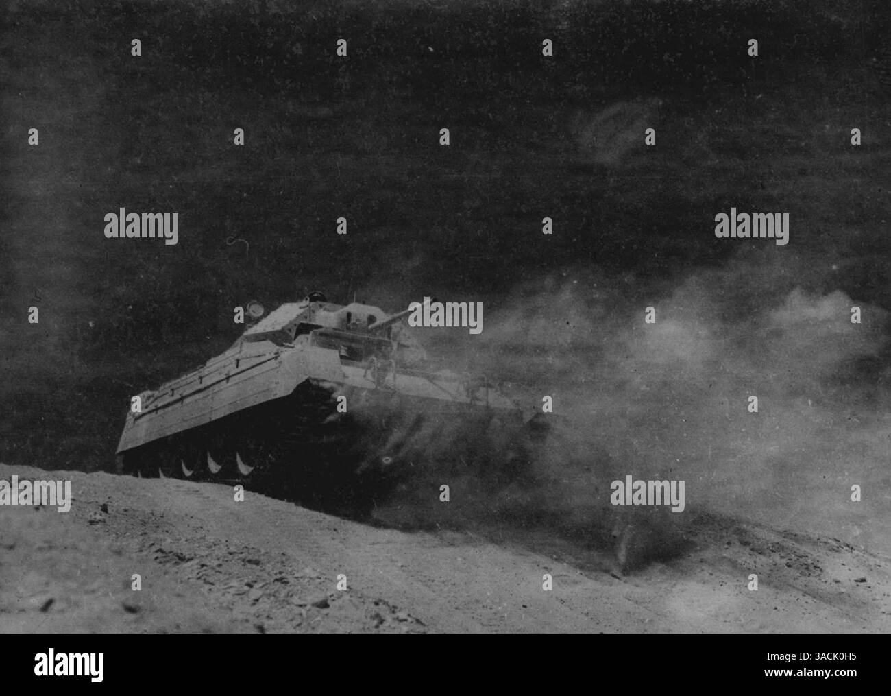 Il y a quatorze mois, une unité d'atelier de la brigade des chemins de fer et des ports sud-africaine a été recrutée et a quitté l'union en un temps record de dix jours. Aujourd'hui, ces hommes sont l'épine dorsale d'un grand dépôt de réparation de chars, en Égypte, qui fait autant que n'importe quelle unité combattante pour retarder la course de l'axe vers l'est. Travaillant à un rythme jamais atteint auparavant, ils remettent les chars dans la ligne de tir aussi vite que la bataille et l'usure des conditions désertiques les assomment. Leur travail a gagné la gratitude et les éloges du général Auchinleck. Ce char réparé sud-africain le bouscule Banque D'Images