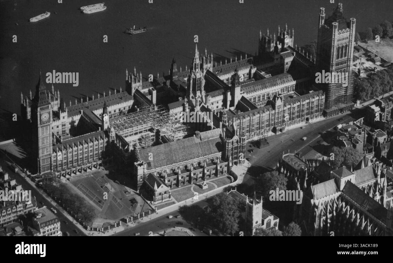 La nouvelle Chambre des communes. Cette nouvelle photographie des chambres du Parlement, prise d'un avion spécialement affrété, montre (centre gauche des bâtiments) l'échafaudage qui marque la construction de la nouvelle Chambre des communes. Cette étude d'angle inhabituelle de la « l'autre des parlements » à côté de la Tamise montre le célèbre « Big Ben » sur la gauche, et la tour Victoria sur la droite. Le Président de la Chambre des communes, le colonel Clifton Brown, est demain (mercredi) pour jeter la pierre angulaire de la nouvelle Chambre des communes, qui est en train d'être reconstruite après son blitzing de guerre. La cérémonie, à laquelle le premier ministre, avec Banque D'Images