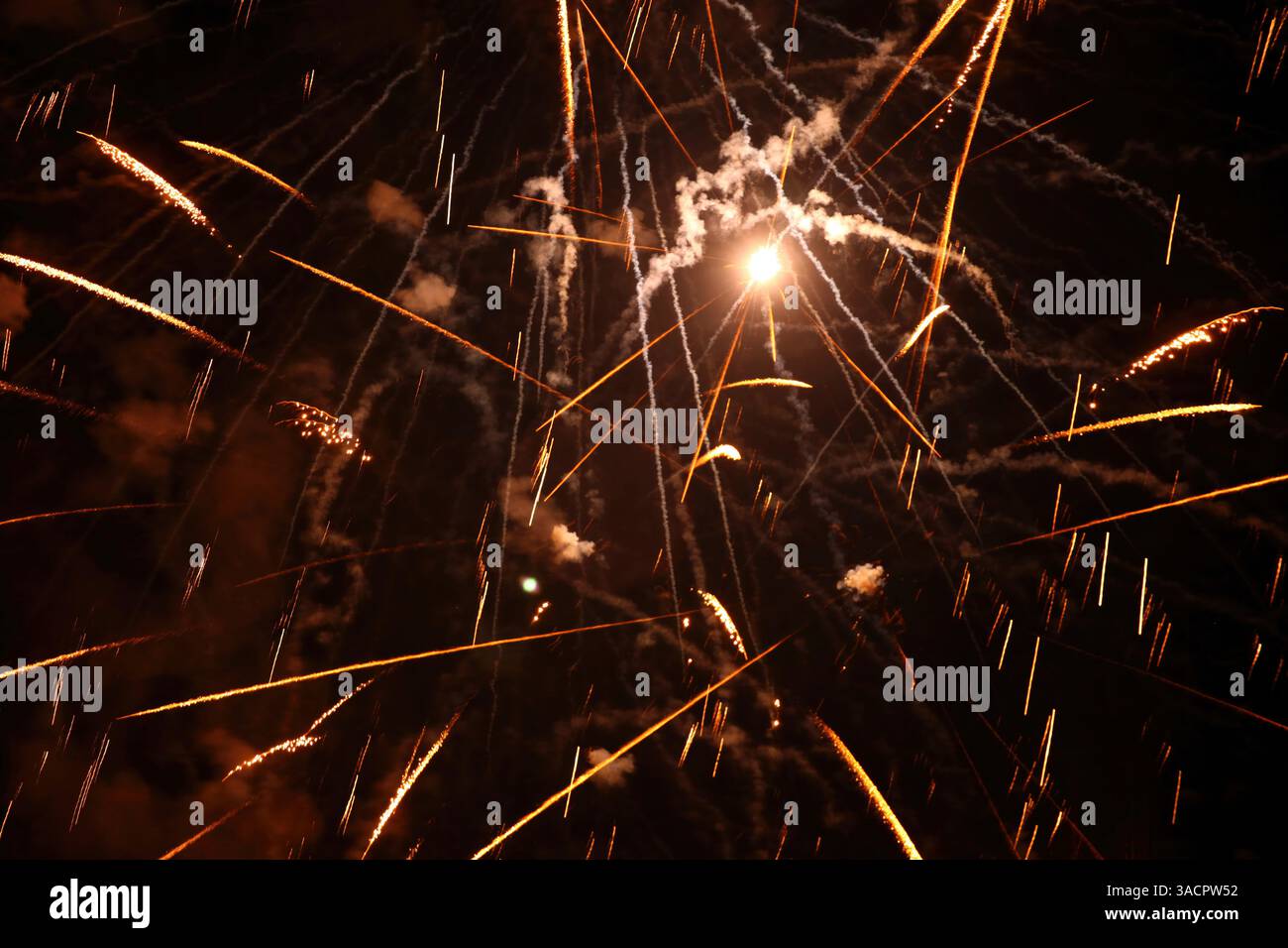 Feux d'artifice orange et blanc éclatant dans le ciel nocturne, créant un spectacle spectaculaire de lumière et de couleur Banque D'Images