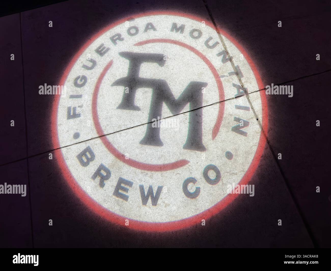 Santa Barbara, Californie, États-Unis - 17 février 2025 : un logo Figueroa Mountain Brew Co. est projeté sur un trottoir la nuit. Banque D'Images