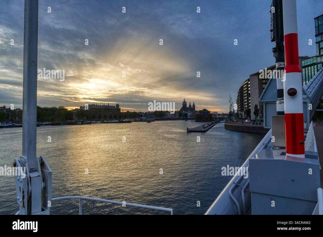 Vue sur le port et la vieille ville historique d'Amsterdam au coucher du soleil Banque D'Images