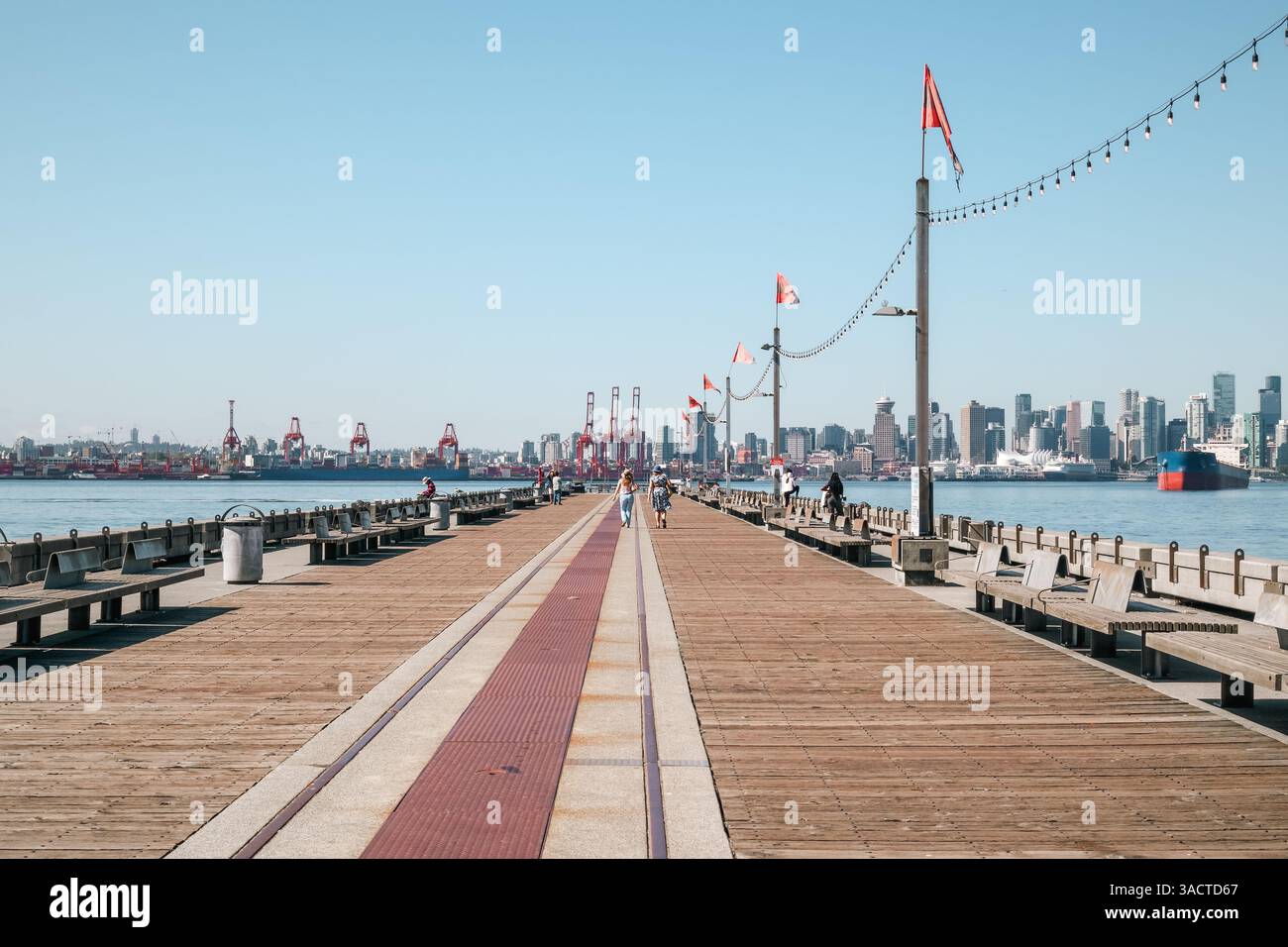 Les gens apprécient la jetée avec vue sur le centre-ville de Vancouver. Loisirs de ville d'été à pied par l'océan. Burrard Dry Dock Pier, North Vancouver. Mise au point sélective. Ni Banque D'Images