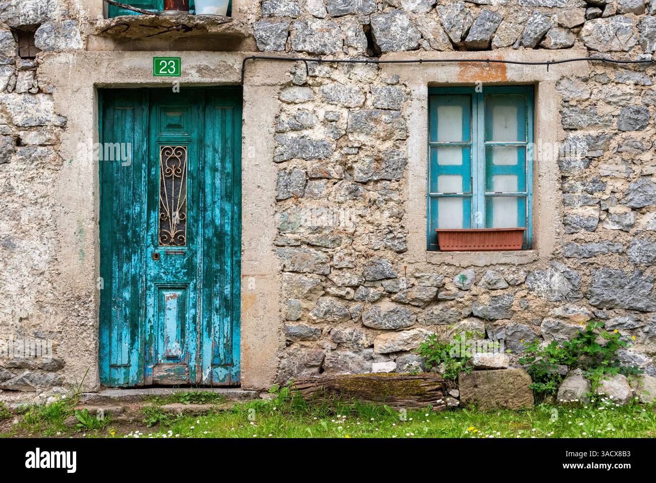 Pittoresque porte peinte en bleu et fenêtre d'une vieille maison dans le village de Cain de Valdeon, à la fin du sentier de randonnée de la gorge de Cares dans les montagnes Picos de Europa dans les Asturies, au nord de l'Espagne Banque D'Images