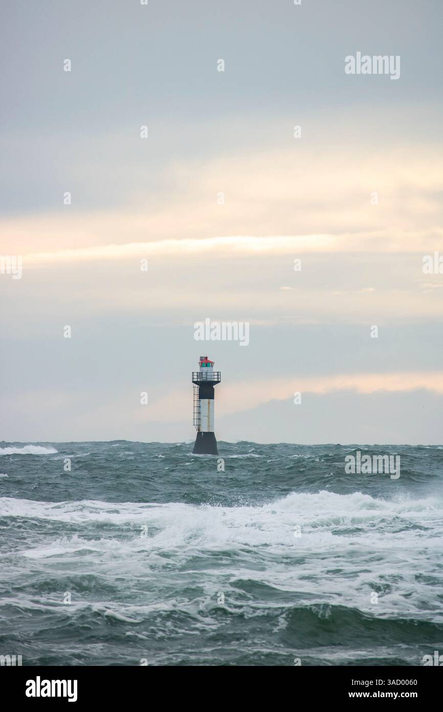 Un phare dans une tempête, mer sauvage le soir, coucher de soleil sur une côte avec de nombreux rochers dans la mer du Nord. Paysage marin en Suède, Scandinavie, Europe Banque D'Images