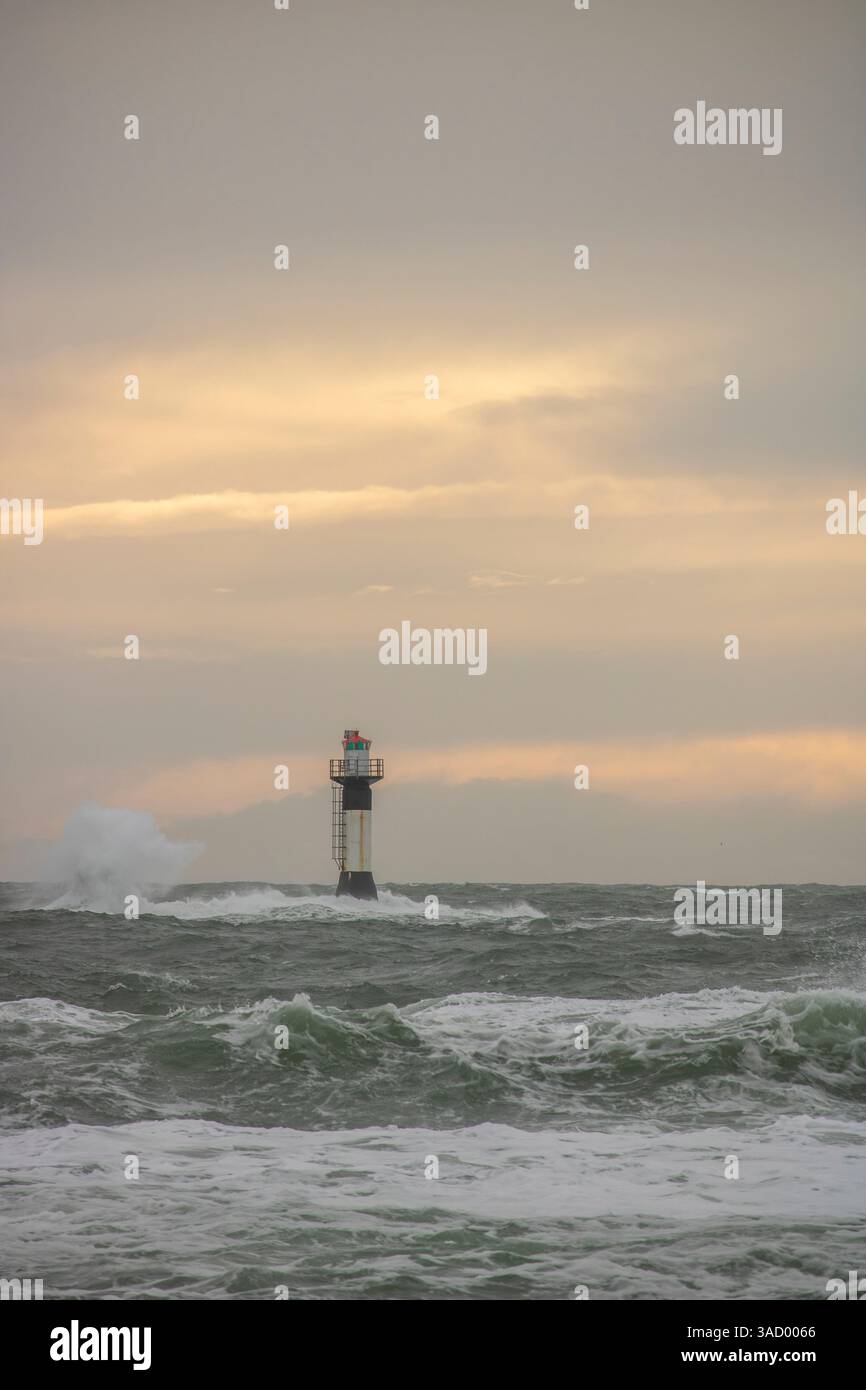 Un phare dans une tempête, mer sauvage le soir, coucher de soleil sur une côte avec de nombreux rochers dans la mer du Nord. Paysage marin en Suède, Scandinavie, Europe Banque D'Images
