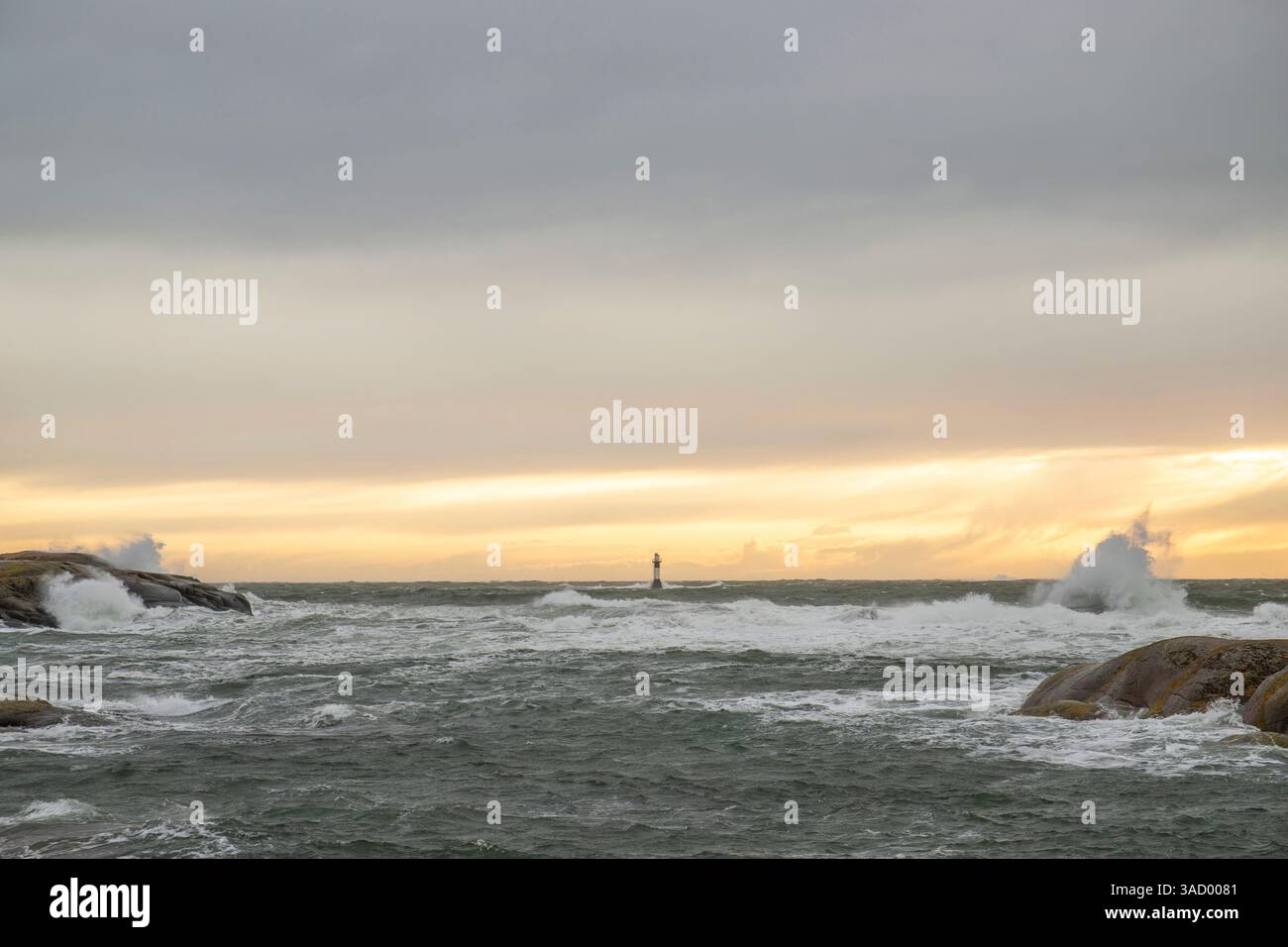 Un phare dans une tempête, mer sauvage le soir, coucher de soleil sur une côte avec de nombreux rochers dans la mer du Nord. Paysage marin en Suède, Scandinavie, Europe Banque D'Images