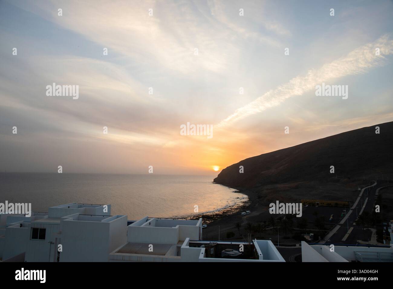 Coucher de soleil dans une baie. Beau paysage photographié avec une vue sur une côte aride à marée basse. À une lumière calima, sable du désert au crépuscule avec une grande couleur de ciel à Gran Tarajal, îles Canaries, Fuerteventura, Espagne Banque D'Images