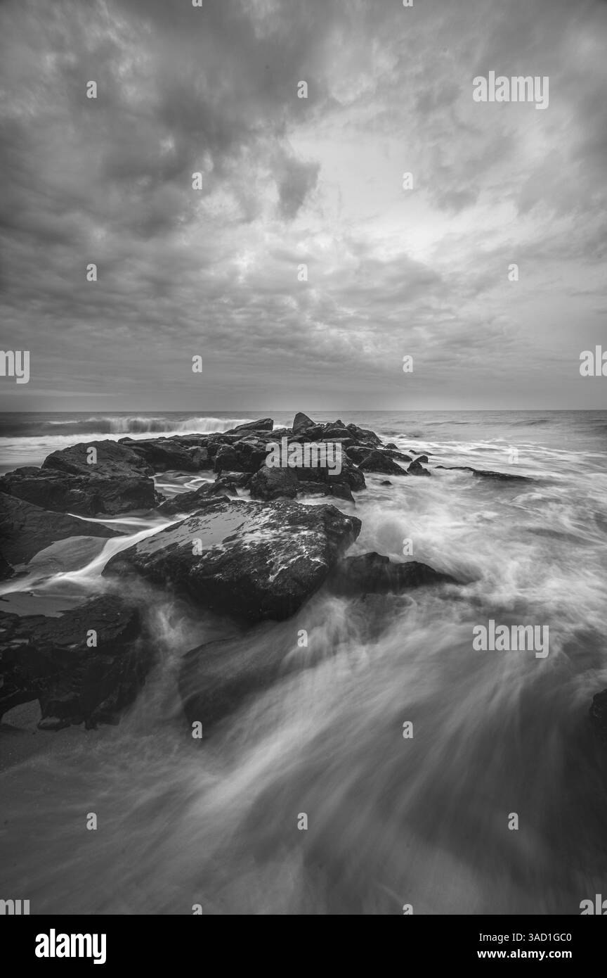 États-Unis, New Jersey, Cape May National Seashore. Océan et vagues frappant les rochers au lever du soleil. ©Jay O'Brien / Galerie Jaynes / DanitaDelimont.com Banque D'Images