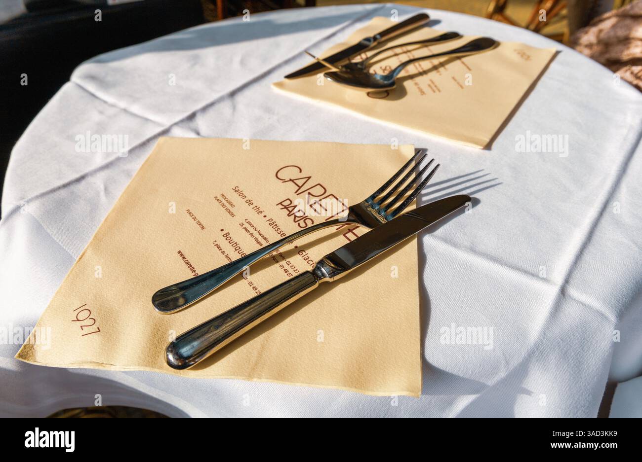 Table avec nappe blanche et serviette avec couverts dans le restaurant Carette à Paris, France - 30 octobre 2024 Banque D'Images