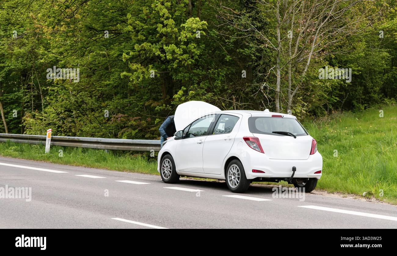 Voiture cassée avec capot ouvert sur le côté de l'autoroute. Photo de haute qualité Banque D'Images