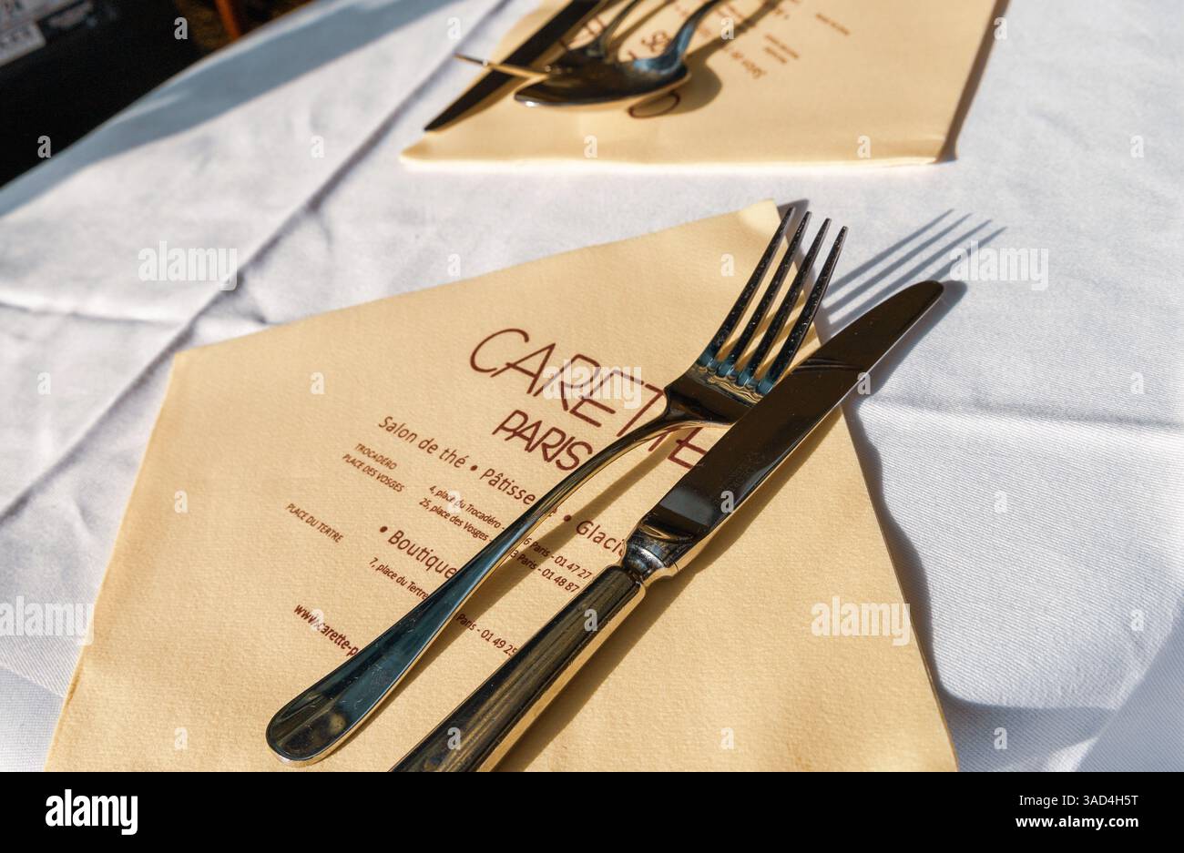 Table avec nappe blanche et serviette avec couverts dans le restaurant Carette à Paris, France - 30 octobre 2024 Banque D'Images