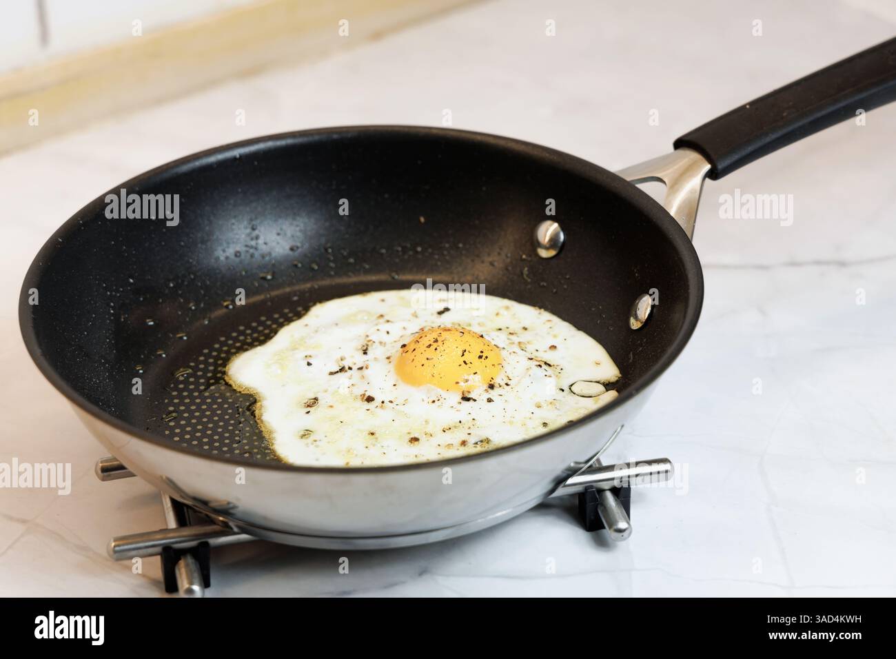Petit déjeuner servi sur la table de la cuisine avec un oeuf frit dans une poêle. Photo de haute qualité Banque D'Images