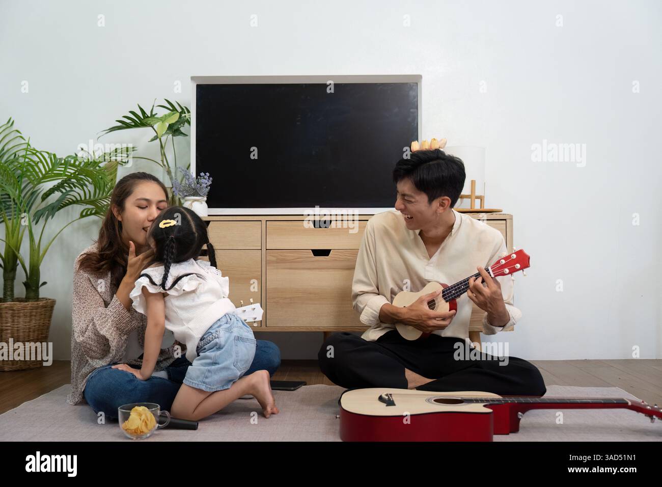 Divertissement en famille et éducation musicale. Une famille charmante jouant des instruments ensemble à la maison. Banque D'Images