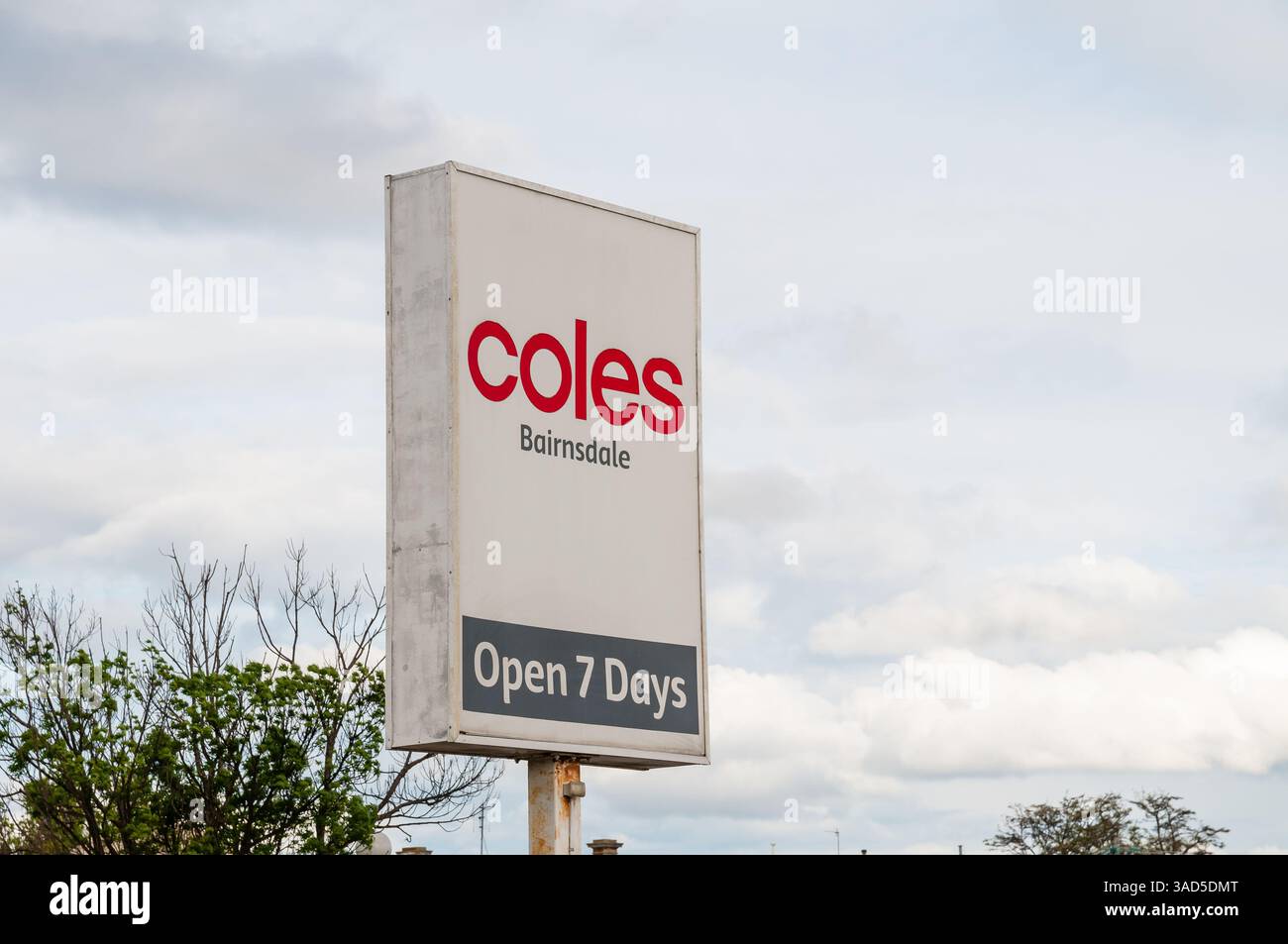 Coles supermarché signe Bairnsdale, publicité de magasin de détail, ouvert 7 jours, fond de ciel nuageux, Nouvelle-Galles du Sud, Australie Banque D'Images