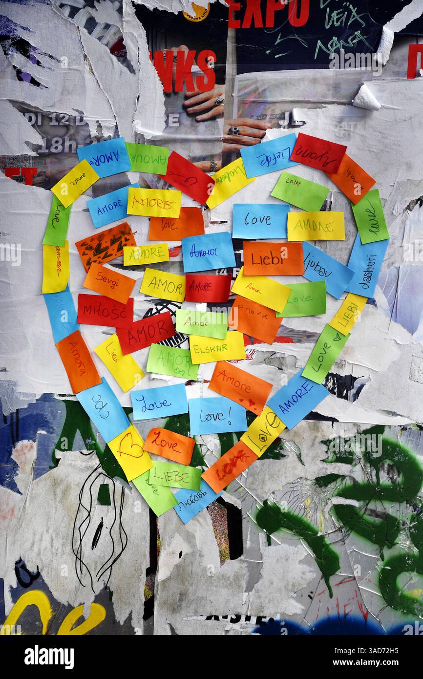Mot LOVE écrit dans toutes les langues avec des notes adhésives sur un mur dans la rue de Paris - France Banque D'Images