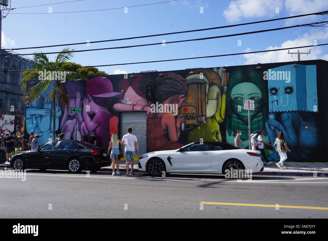 Les touristes font la queue aux emblématiques peintures murales en plein air de Wynwood Walls et à la galerie de graffitis par une journée ensoleillée à Miami, en Floride. Banque D'Images