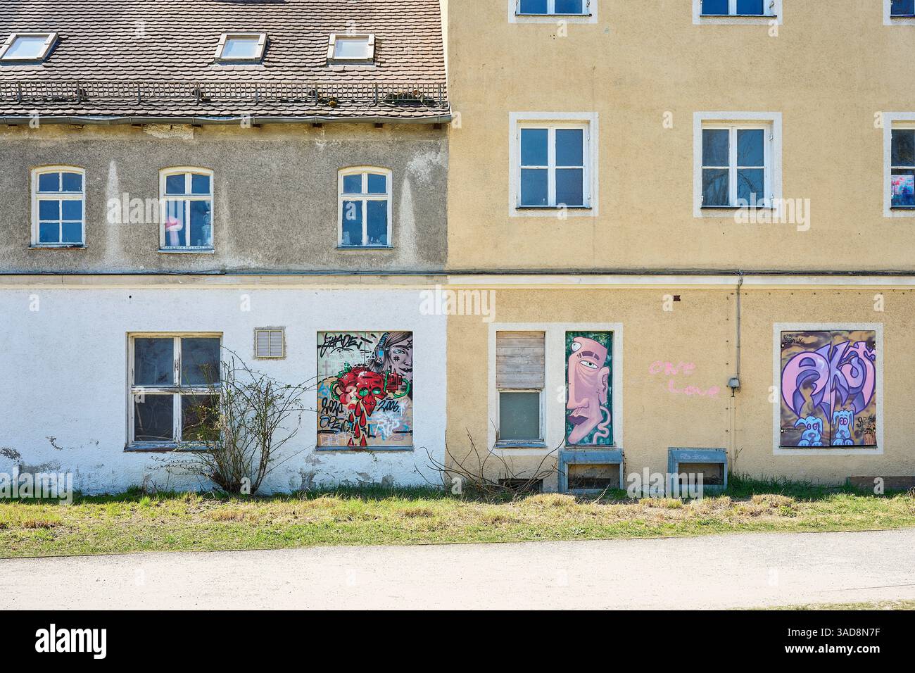 zwei Häuserfasaden die teilweise neu gestrichen sind und Flächen aufweisen, die mit Streetart gestaltet sind. Banque D'Images