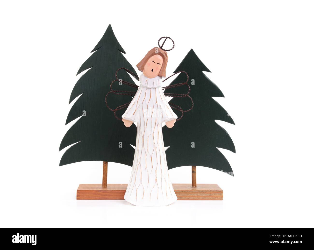 Ange en bois isolé devant les arbres de Noël. Arbre de Noël en bois avec gardien de Noël mignon. Design minimaliste. Décoration de saison des fêtes ou célébrité Banque D'Images