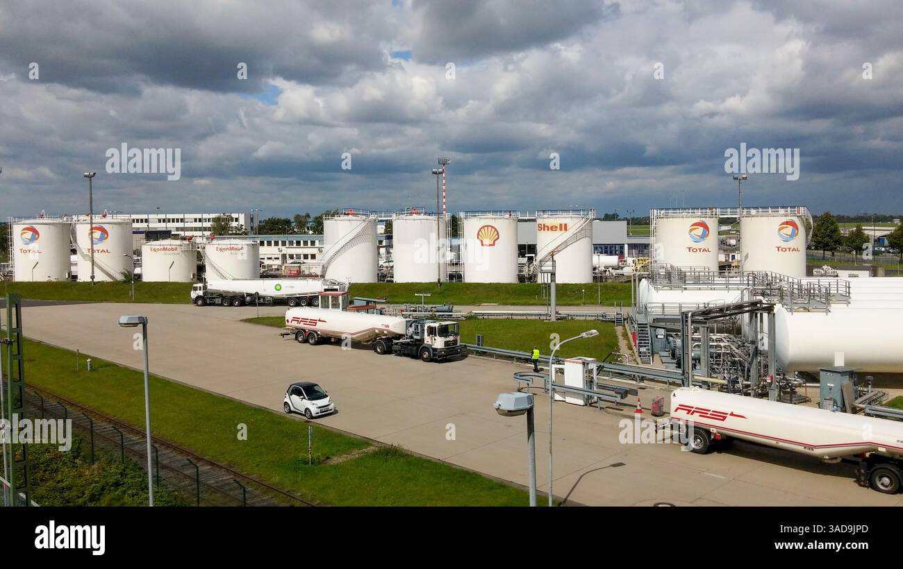 Un grand site industriel avec plusieurs réservoirs de stockage de carburant Shell et total, avec des camions stationnés à proximité pour le chargement et le déchargement. Le ciel est PA Banque D'Images