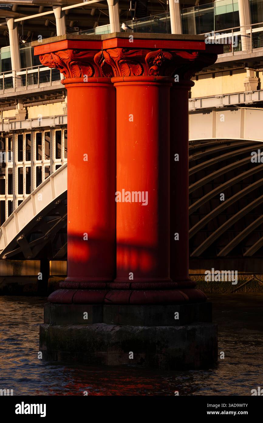 Les ombres se projettent sur les colonnes de fer rouge qui soutenaient autrefois le pont du London, Chatham & Dover Railway sur la Tamise. Blackfriars, Londres, Royaume-Uni. 18 Banque D'Images