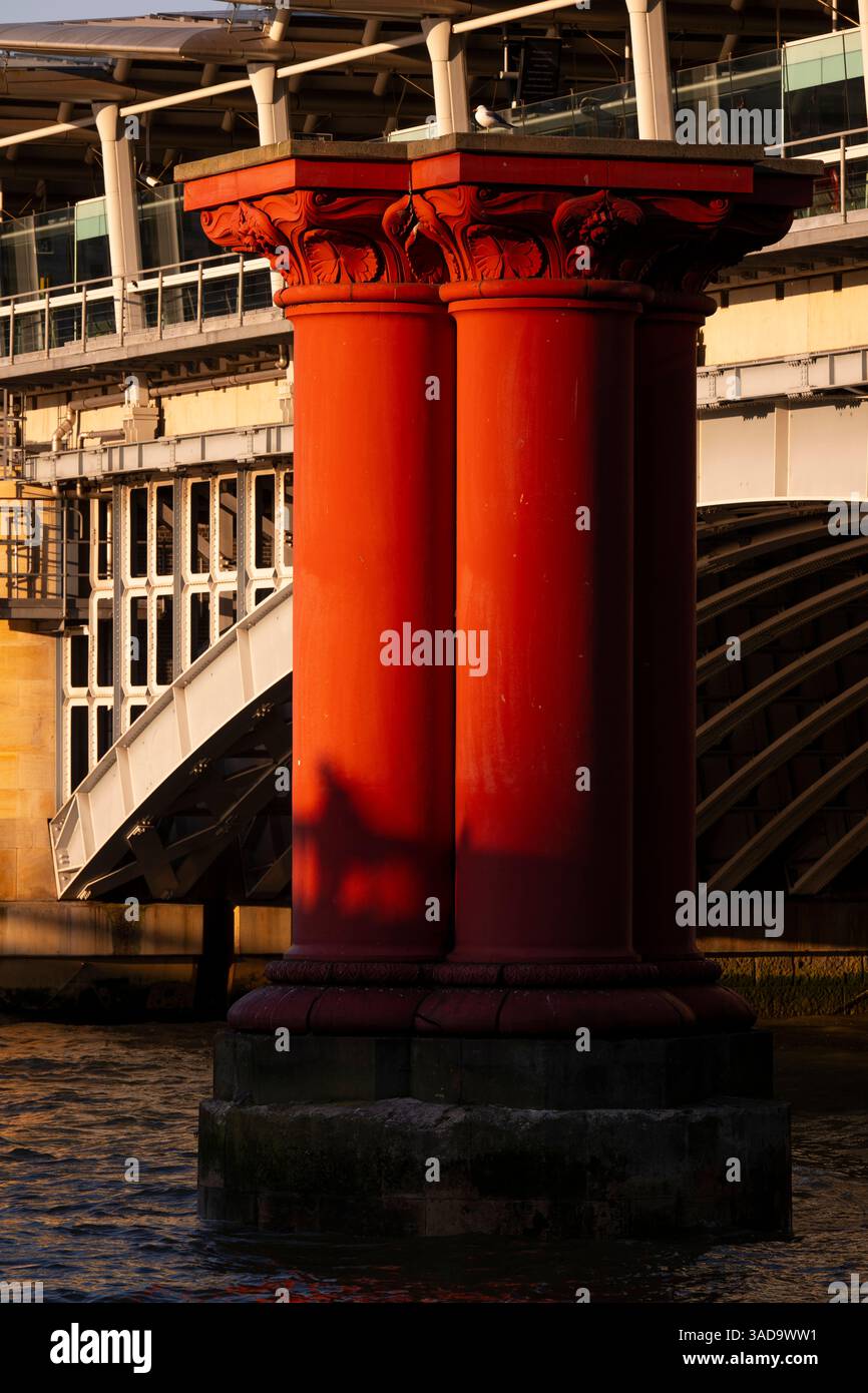 Les ombres se projettent sur les colonnes de fer rouge qui soutenaient autrefois le pont du London, Chatham & Dover Railway sur la Tamise. Blackfriars, Londres, Royaume-Uni. 18 Banque D'Images