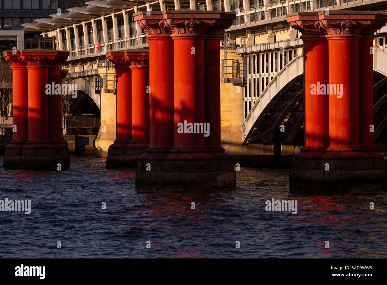 Les ombres se projettent sur les colonnes de fer rouge qui soutenaient autrefois le pont du London, Chatham & Dover Railway sur la Tamise. Blackfriars, Londres, Royaume-Uni. 18 Banque D'Images