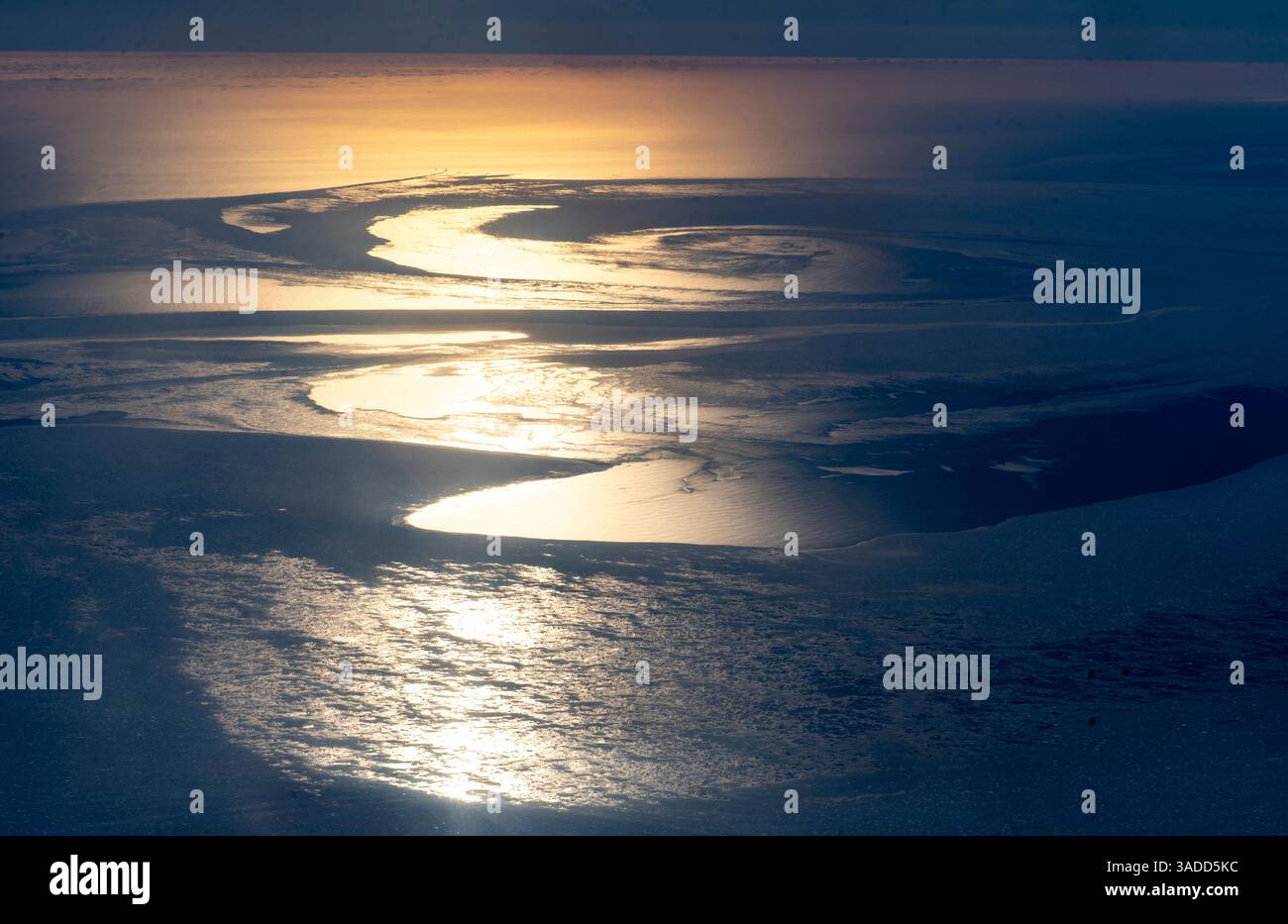 Vue aérienne d'une surface d'eau scintillante avec des motifs tourbillonnants reflétant la lumière du soleil, créant une atmosphère sereine et tranquille. Banque D'Images