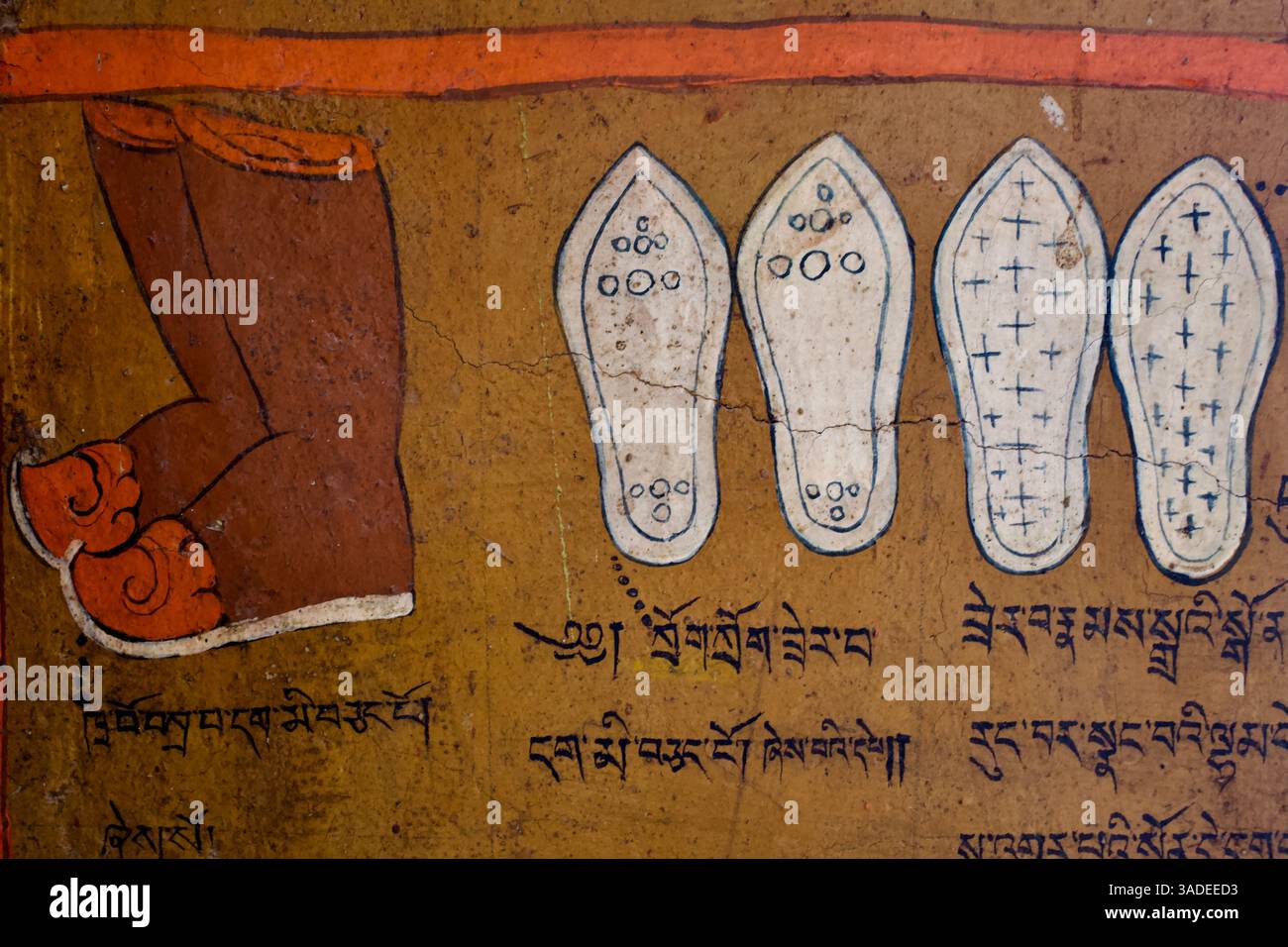 Représentation des empreintes symboliques de Bouddha avec des marques sacrées et l'écriture tibétaine qui l'accompagne, détail mural dans le monastère de Likir, Ladakh, Inde. Banque D'Images