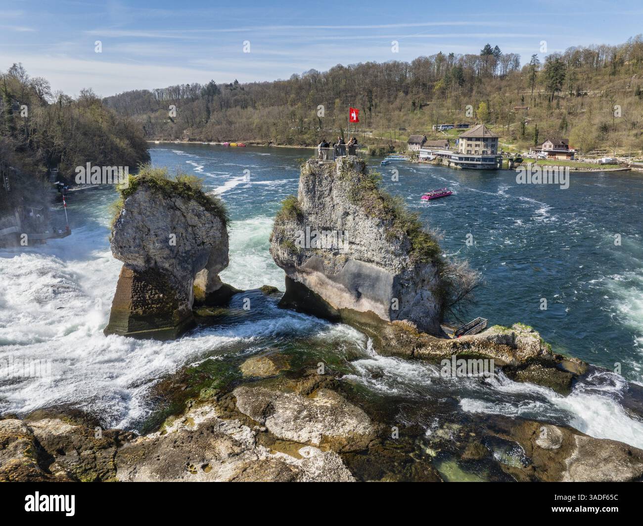 Vue aérienne des chutes du Rhin à basse eau au printemps, avec des touristes sur la plate-forme d'observation, à droite le restaurant panoramique Schloessli Woerth, Banque D'Images