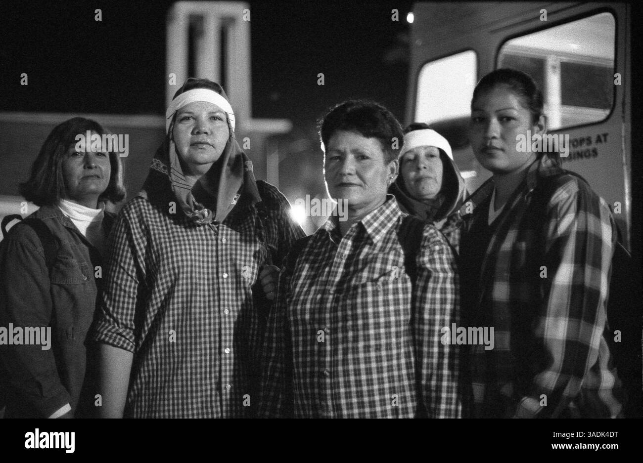 08 décembre 2004 ; Calexico, MEXIQUE, États-Unis ; chaque matin, dès 2 h DU MATIN, ces femmes se rendent de Mexicali au port d'entrée de Calexico. Ils attendent pour monter à bord des bus de travail qui les transportent jusqu’à 75 milles au nord pour leur travail dans les champs de cantaloup de la vallée impériale. Les femmes représentent environ 20 % de la main-d'œuvre agricole. Le migrant Project se propose de faire une chose : donner un visage humain aux gens, qu'il s'agisse de familles vivant dans les terrains de terre de la Mecque pendant des mois à la fois pendant la saison des raisins, de cueilleurs de tomates à Stockton qui courent à travers les champs boueux pesant trente livres Banque D'Images