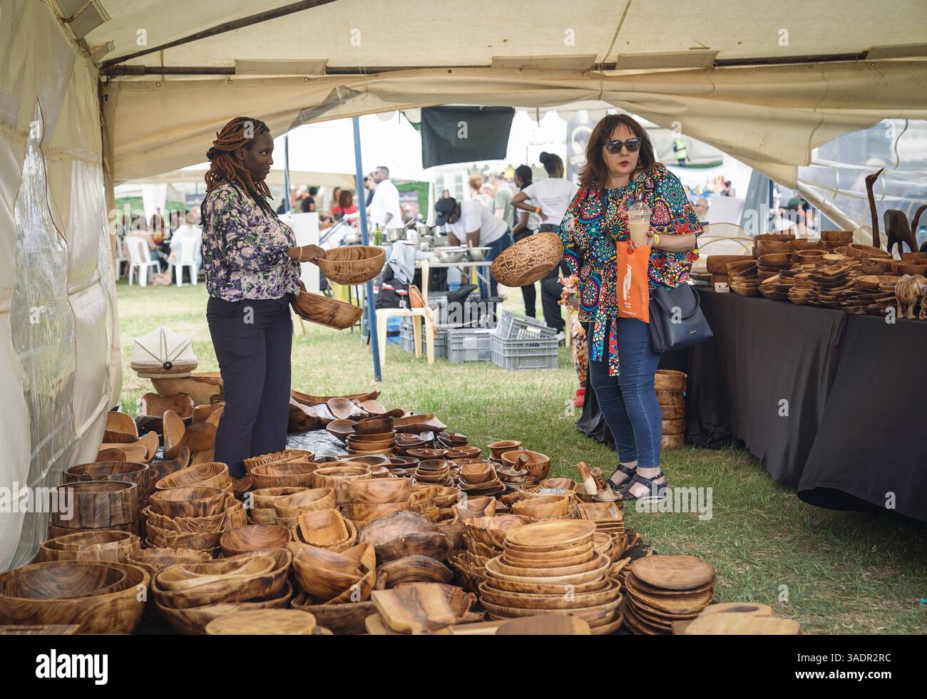 Nairobi, Kenya. 5 avril 2025. Une femme achète un bol en bois sculpté dans un marché de Pâques à Nairobi, Kenya, le 5 avril 2025. Crédit : Han Xu/Xinhua/Alamy Live News Banque D'Images