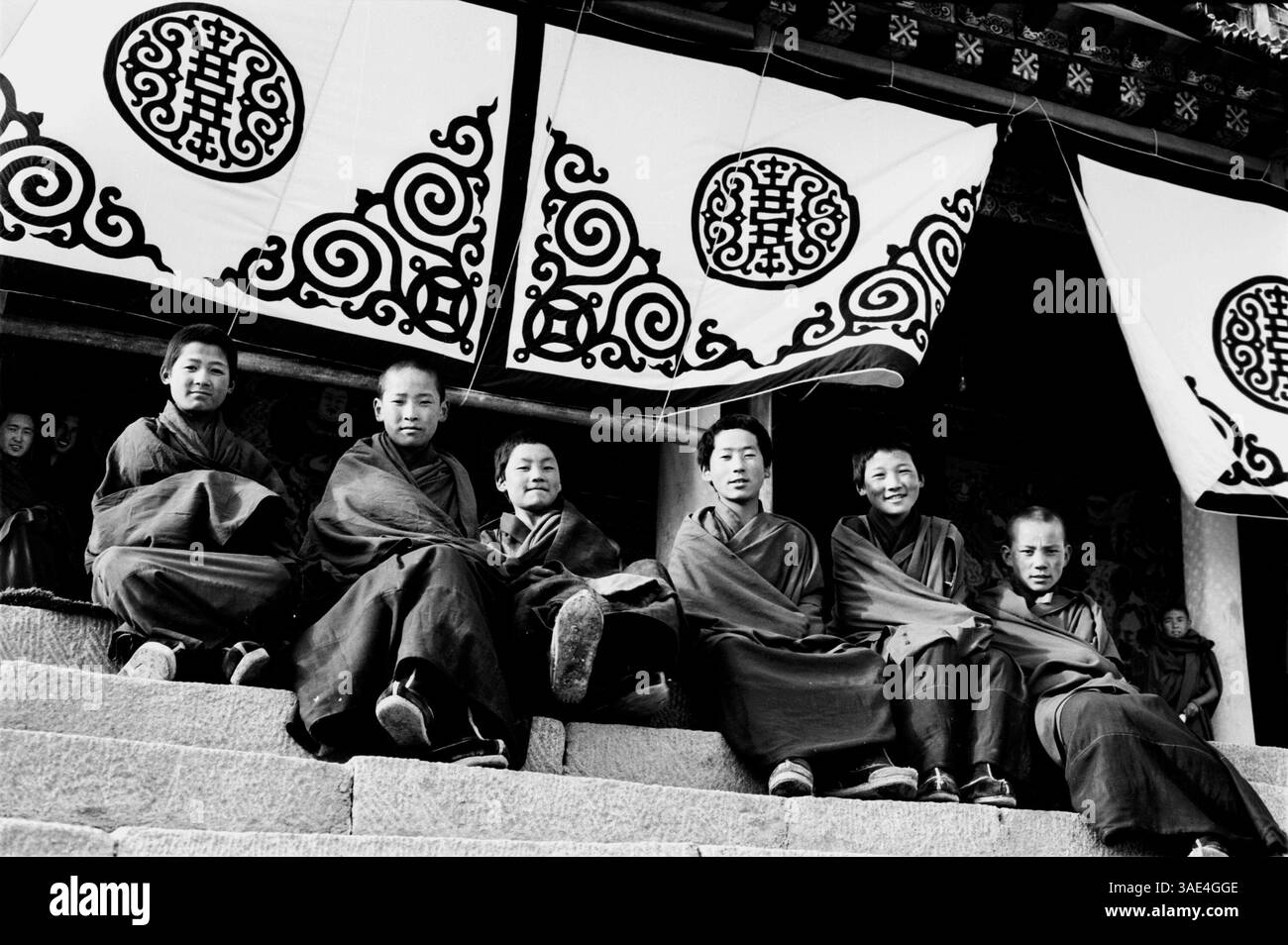 12 avril 1996 ; Hezhou, province du Gansu, CHINE ; curieux moines bhuddistes tibétains assis sur les marches de thier nouveau monastère à Hezhou .. (Crédit image : Ruaridh Stewart/ZUMAPRESS.com) Banque D'Images
