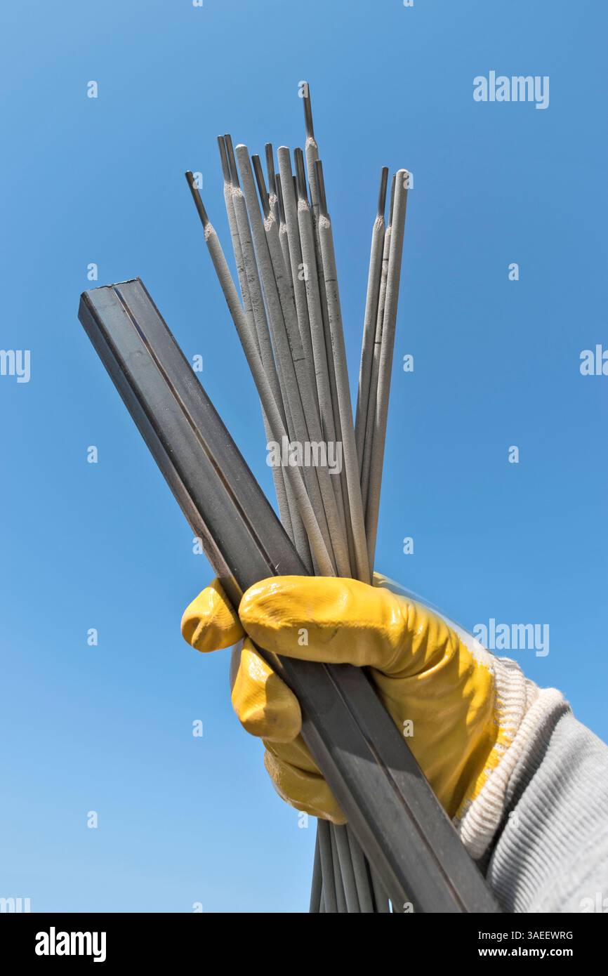 Travailleur prêt à travailler avec des électrodes de soudage et profil métallique. Baguette de soudage en acier. ELECTRODE de soudage. Bâton de soudage en fer et acier. Banque D'Images