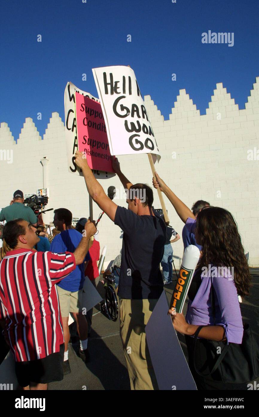 06 août 2001 ; Turlock, CA, États-Unis ; Eric Vance s'est faufilé dans un rassemblement de soutien à Gary Condit sur la propriété Assyrian American Civic Club à Turlock, en Californie. Les partisans de Condit (dont Liseth Guizar, 22 ans, à droite) ont tenté de protéger les médias et les participants de sa pancarte qui dénonçait le député. (Crédit image : Eric Slomanson/ZUMAPRESS.com) Banque D'Images