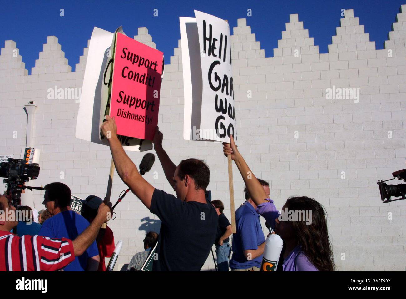 06 août 2001 ; Turlock, CA, États-Unis ; Eric Vance s'est faufilé dans un rassemblement de soutien à Gary Condit sur la propriété Assyrian American Civic Club à Turlock, en Californie. Les partisans de Condit (dont Liseth Guizar, 22 ans, à droite) ont tenté de protéger les médias et les participants de sa pancarte qui dénonçait le député. (Crédit image : Eric Slomanson/ZUMAPRESS.com) Banque D'Images