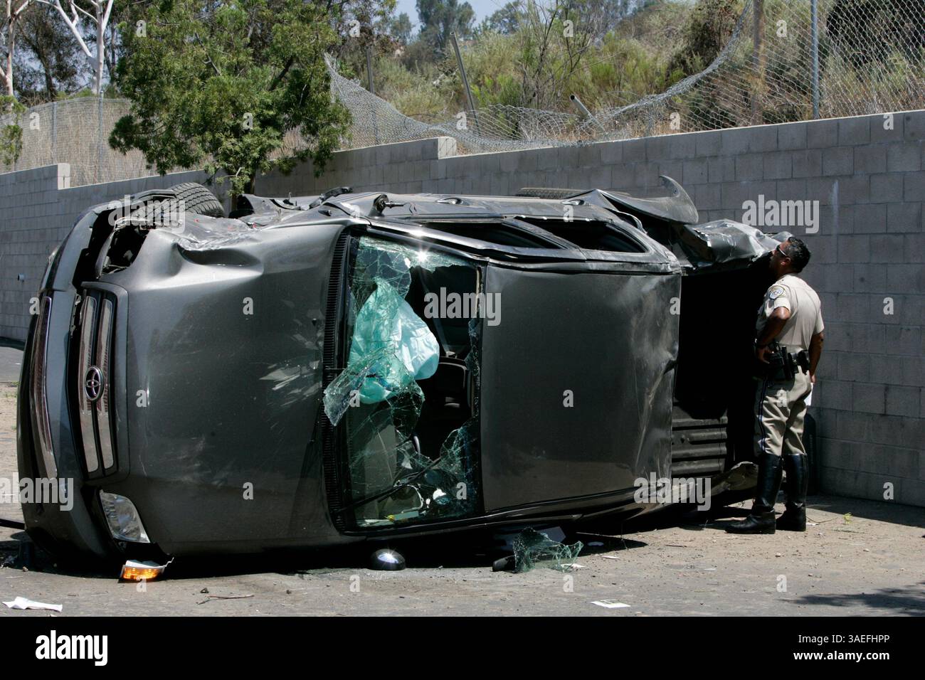 August 15, 2008 San Diego, CA California Highway Patrol Officer ALEX HERRERA regarde une camionnette Toyota qui a atterri sous les voies sud de l'Interstate 15 South (crédit image : San Diego Union-Tribune/ZUMAPRESS.com) Banque D'Images