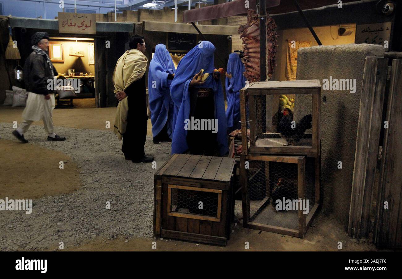 20 octobre 2011 - Camp Lejeune, NC, États-Unis - les joueurs de rôle errent dans une maquette d'un marché rural afghan alors que les Marines de la compagnie Bravo, 2e peloton, 1er bataillon 8e Marines, 2e division des Marines se préparent à démarrer une simulation dans le nouvel entraîneur d'immersion d'infanterie MCBCL au Camp Lejeune, Caroline du Nord, le 20 octobre 2011. L'entrepôt converti de 32 000 pieds carrés soutient la formation de petites unités dans la maquette d'un village rural afghan. (Crédit image : © Chuck Liddy/Raleigh News & observer/MCT/ZUMAPRESS.com) Banque D'Images